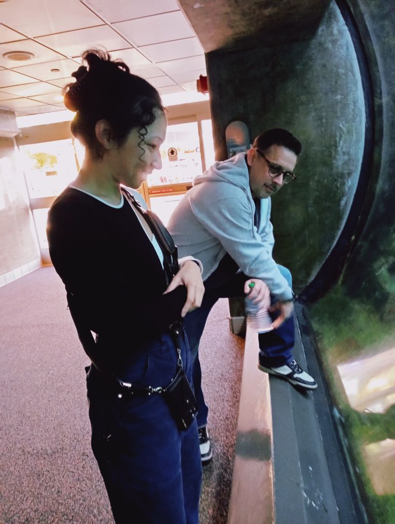 Photo of Alyssa and Marc gazing at the concave wall of a fish tank.
